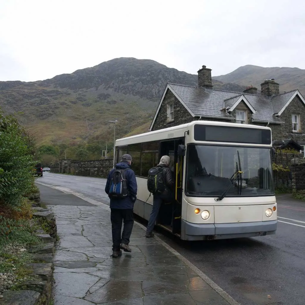A local bus waiting at a stop in a Welsh village below the mountains