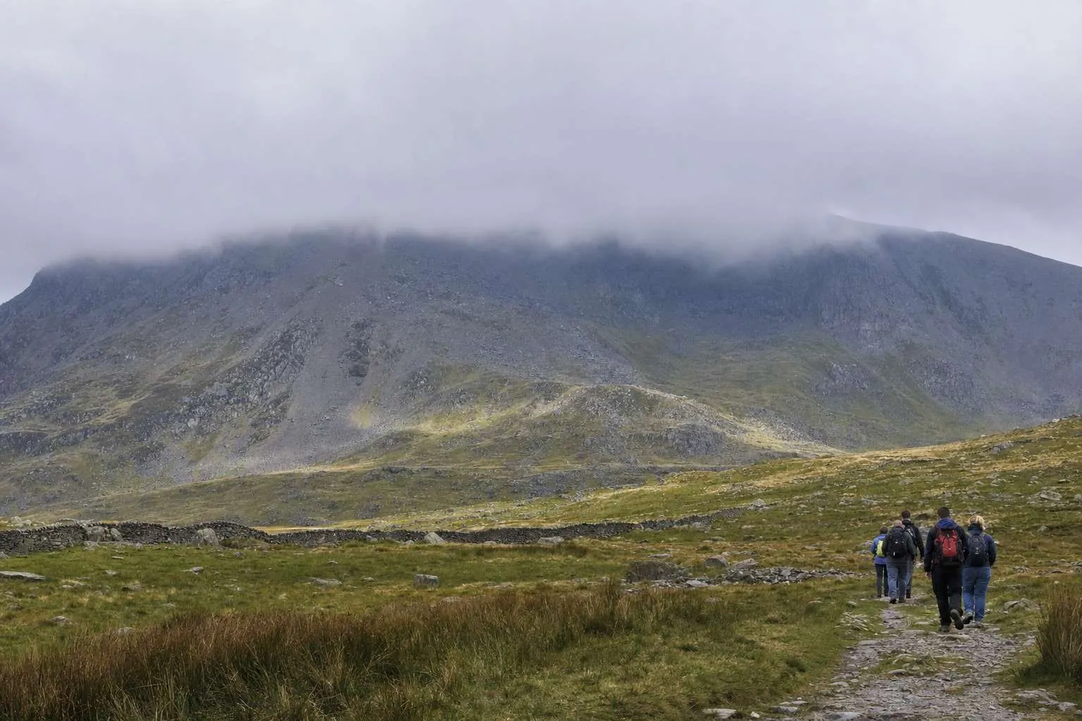 grey cloud pouring over a Snowdonia summit ridge