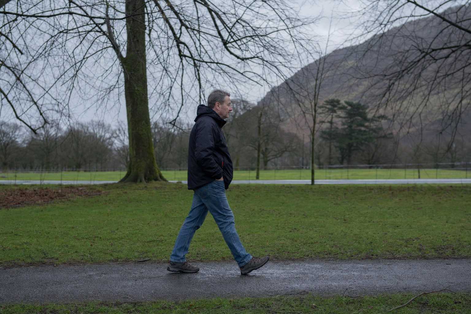 an ordinary person walking at an easy pace in a local park