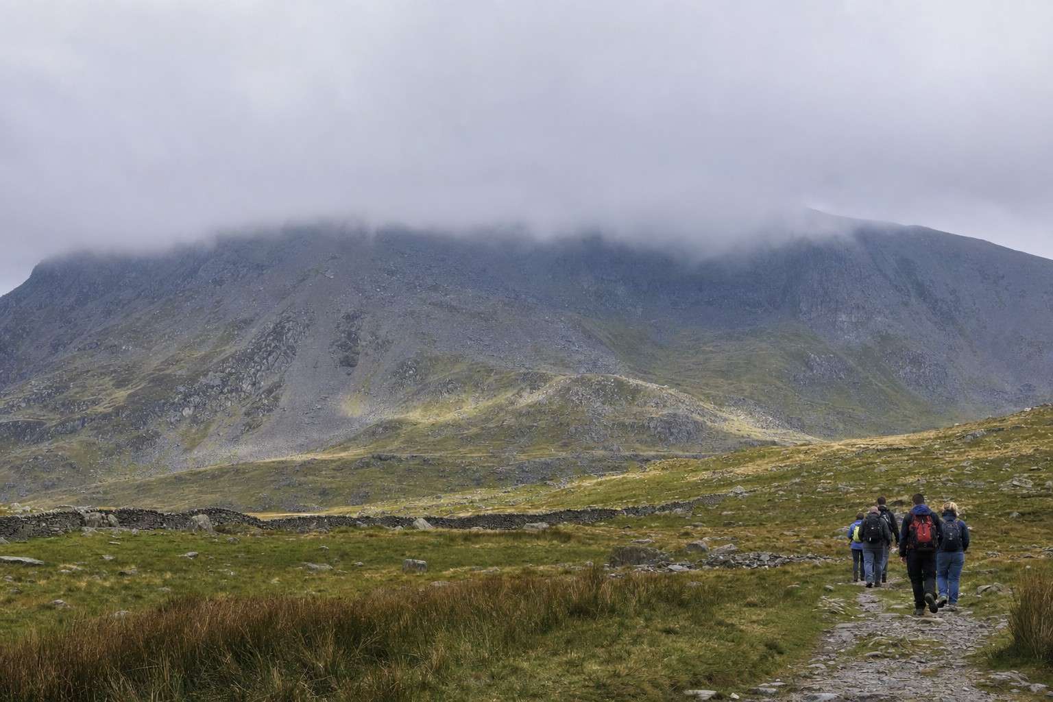 grey cloud pouring over a Snowdonia summit ridge