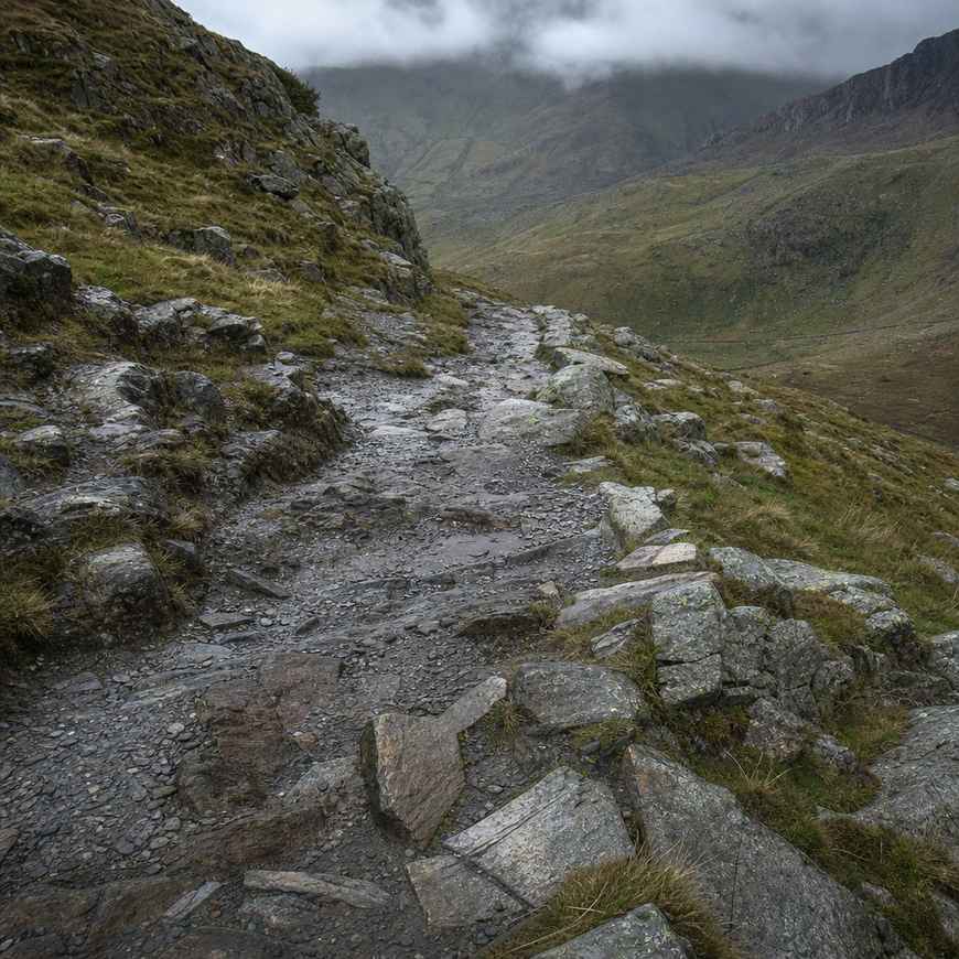 a steep rocky eroded descent path on a Welsh mountain in flat grey light