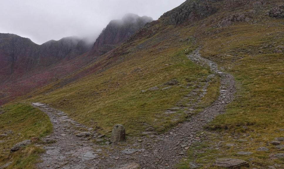 A path junction on a stony Welsh mountainside where two routes divide